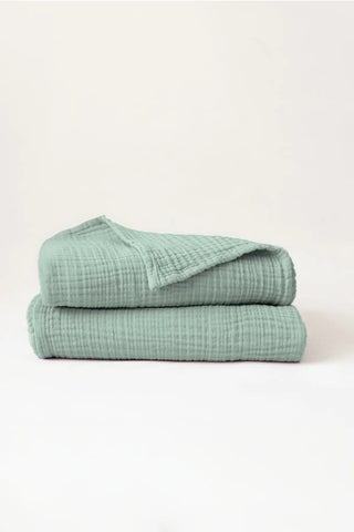 Stacked sage green muslin Turkish cotton towels with soft 4-layer gauze weave, handwoven in Denizli