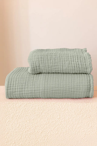 Folded sage green handwoven muslin towels showing the breathable 4-layer cotton texture by VivaMaison