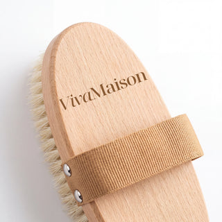 Macro of the laser-engraved logo and the riveted elastic strap on the beech wood body brush - VivaMaison