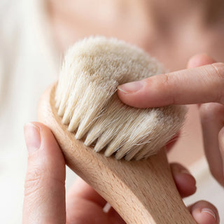 Fingertip pressing into the soft natural bristles of the dry face brush - VivaMaison