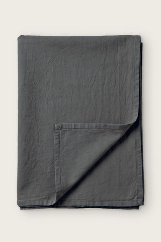 Anthracite handwoven stonewashed Turkish cotton tablecloth, folded with corner turned back. Vintage-soft Denizli, OEKO-TEX. VivaMaison