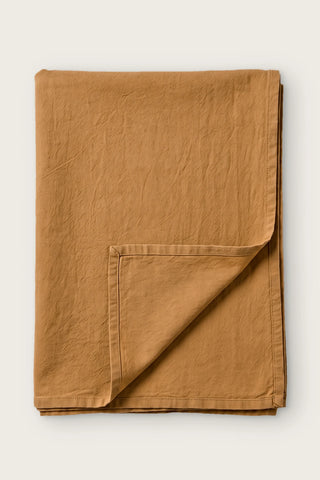Caramel handwoven stonewashed Turkish cotton tablecloth, folded with corner turned back. Vintage-soft Denizli, OEKO-TEX. VivaMaison