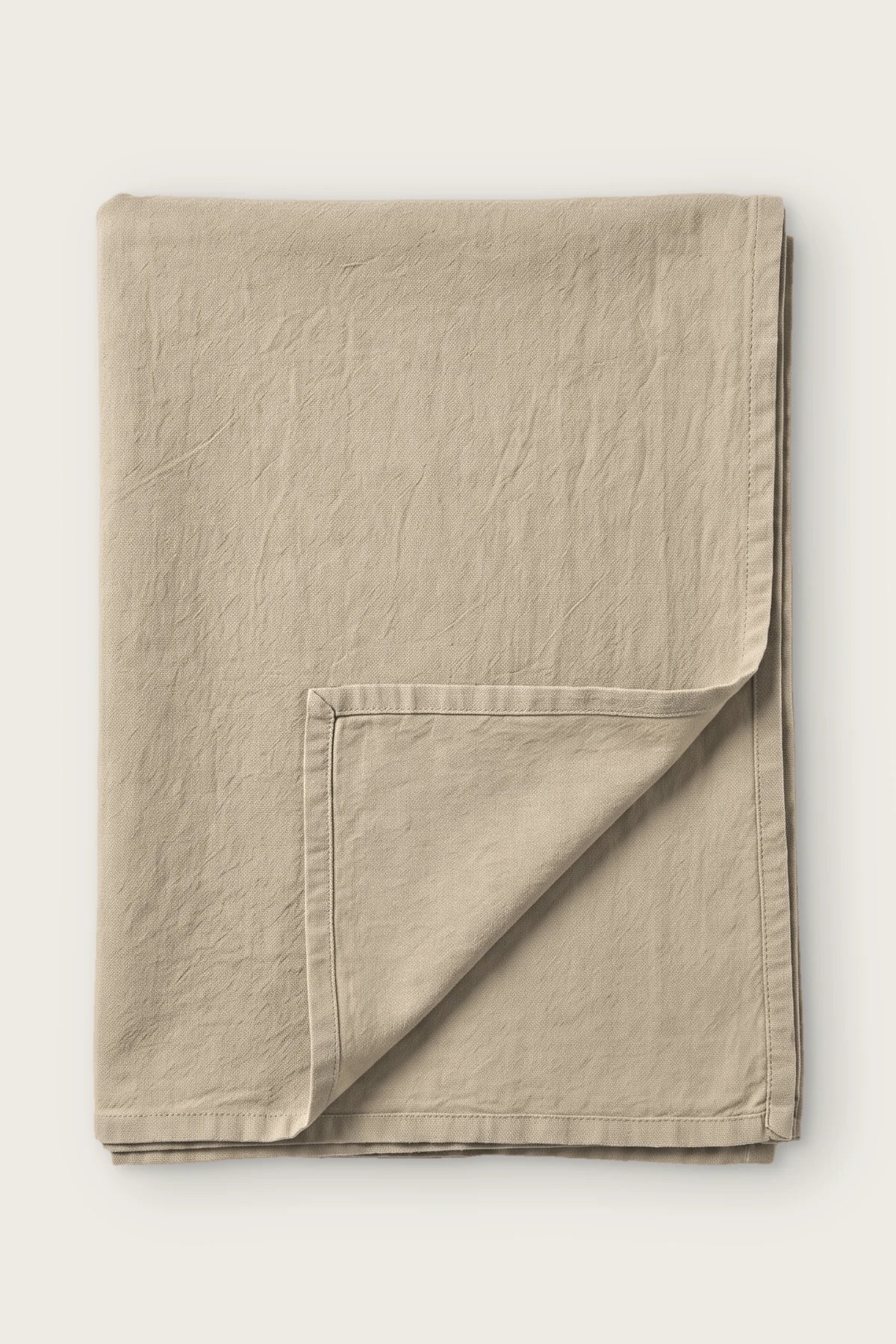 Stone handwoven stonewashed Turkish cotton tablecloth, folded with corner turned back. Vintage-soft Denizli, OEKO-TEX. VivaMaison