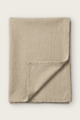Stone handwoven stonewashed Turkish cotton tablecloth, folded with corner turned back. Vintage-soft Denizli, OEKO-TEX. VivaMaison