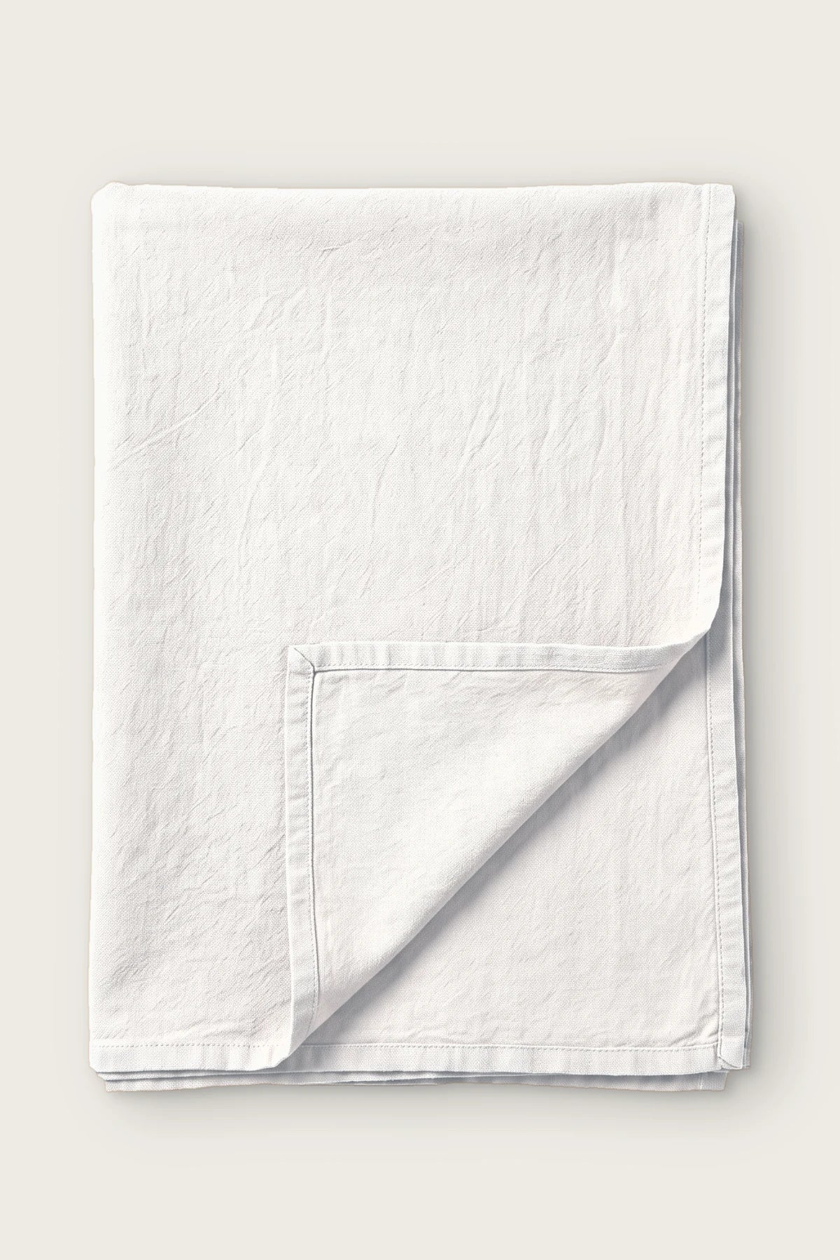 White handwoven stonewashed Turkish cotton tablecloth, folded with corner turned back. Vintage-soft Denizli, OEKO-TEX. VivaMaison
