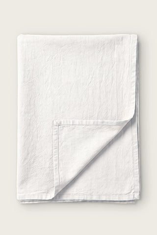 White handwoven stonewashed Turkish cotton tablecloth, folded with corner turned back. Vintage-soft Denizli, OEKO-TEX. VivaMaison