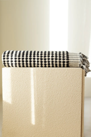 Anthracite White Turkish cotton pom pom towel folded on a plinth - VivaMaison