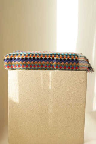 Rainbow Turkish cotton pom pom towel folded on a plinth - VivaMaison