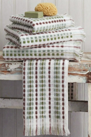 Sage Brown Turkish cotton pom pom towel stacked with one towel draped over the edge - VivaMaison