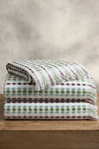 Sage Brown Turkish cotton pom pom towel stacked on a wooden bench - VivaMaison