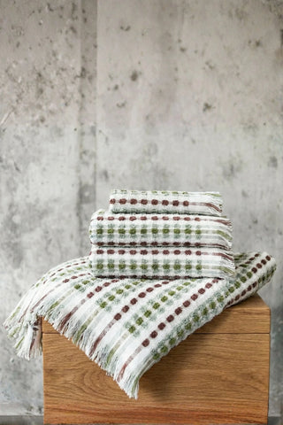 Sage Brown Turkish cotton pom pom towel stacked on a wooden block - VivaMaison
