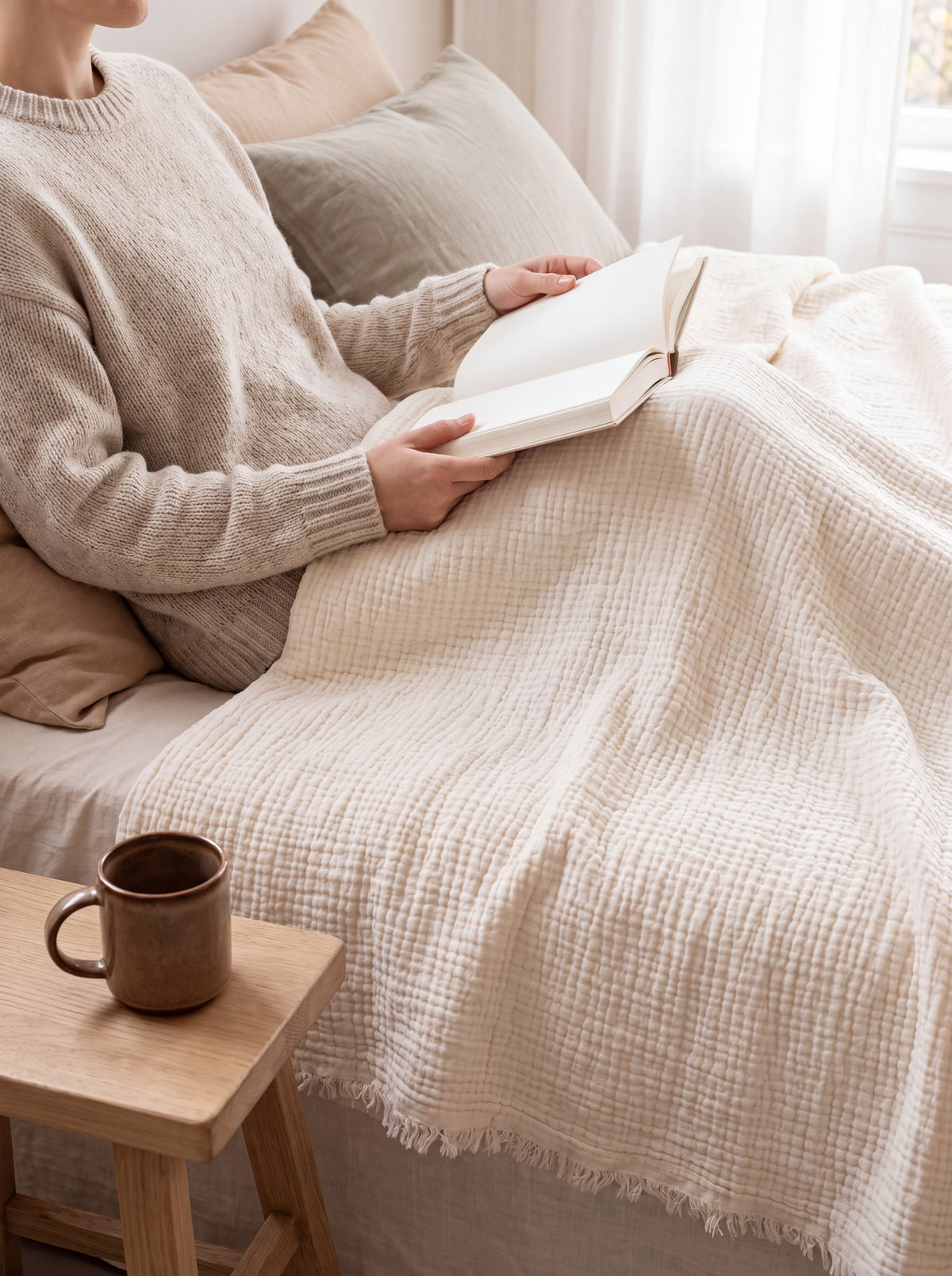 Reading in bed under a muslin blanket