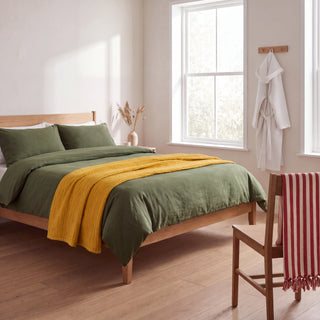 Bedroom with VivaMaison stonewashed green duvet cover, mustard muslin coverlet, white waffle hooded bathrobe and red striped peshtemal