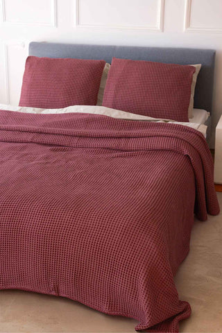 Burgundy waffle bedspread draped on bed showing honeycomb weave texture by Vivamaison