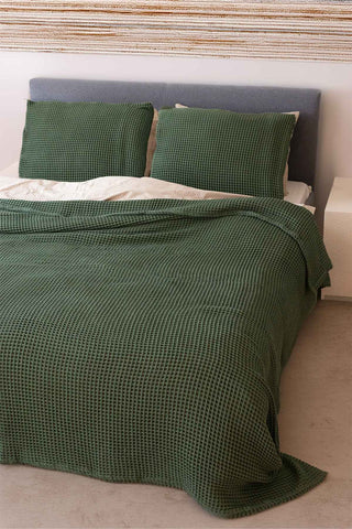 Dark Green waffle bedspread draped on bed showing honeycomb weave texture by Vivamaison