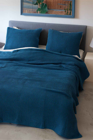 Indigo Blue waffle bedspread draped on bed showing honeycomb weave texture by Vivamaison
