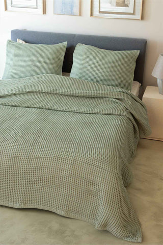 Natural waffle bedspread draped on bed showing honeycomb weave texture by Vivamaison